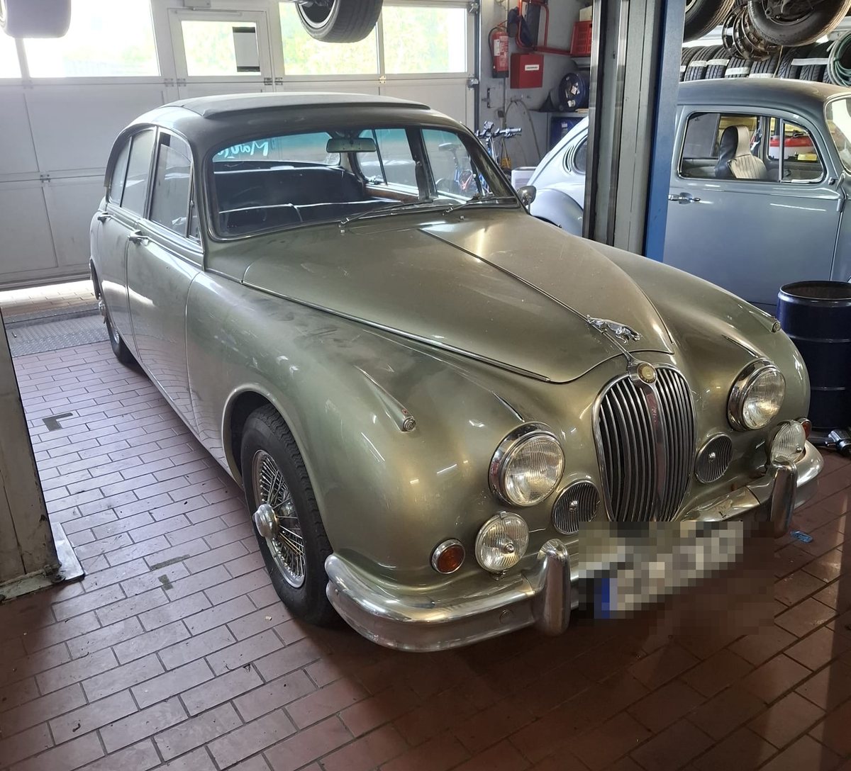 Der Jaguar von vorn, darüber ein Fahrzeug auf der Hebebühne