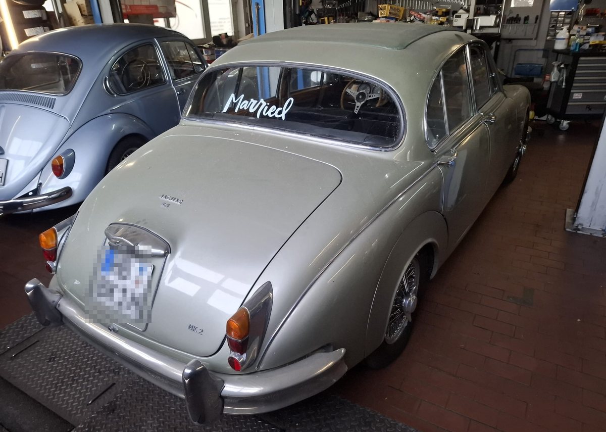 Der Jaguar von hinten, daneben ein VW Käfer