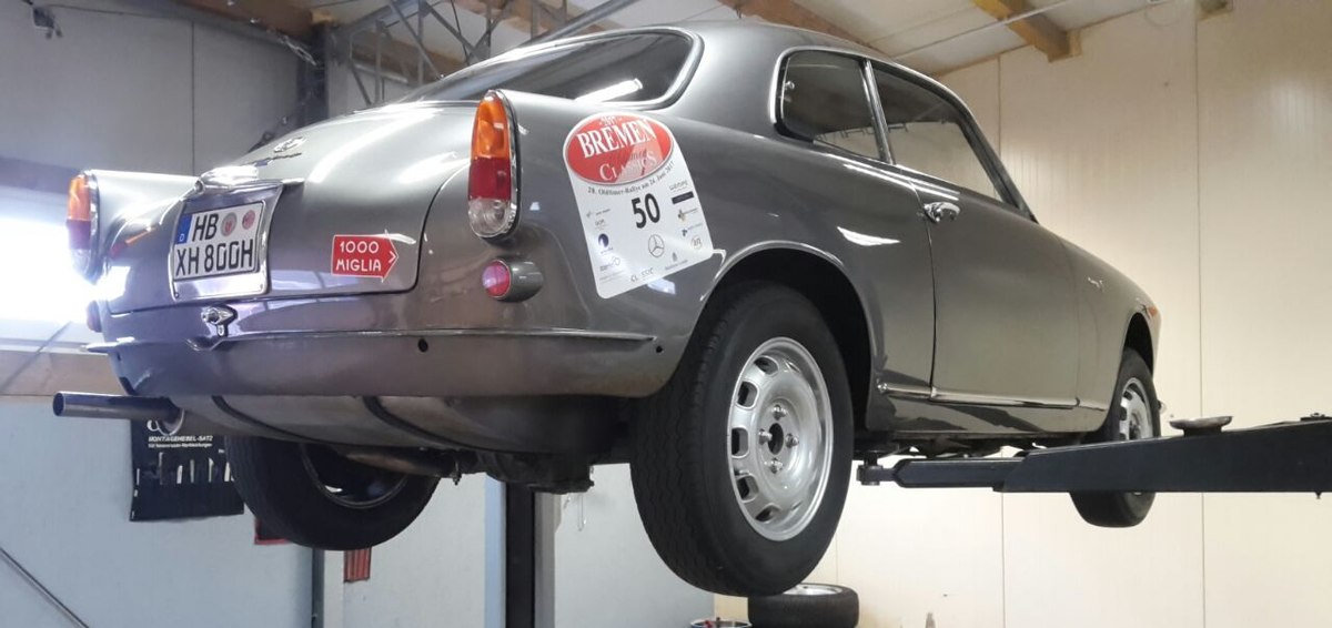 Ein Oldtimer steht auf der Hebebühne